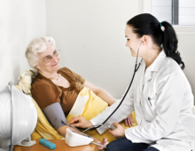 A nurse checking the blood pressure of an elderly