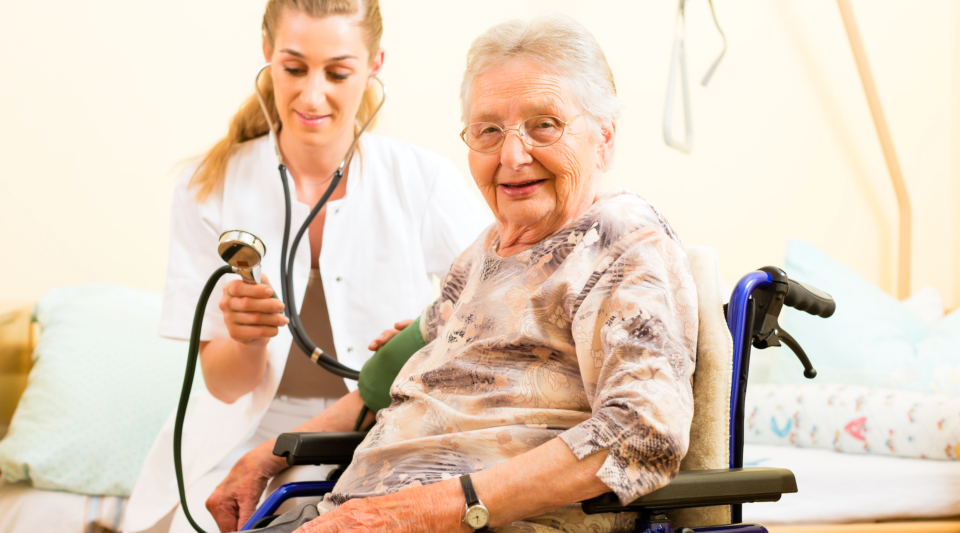 A caregiver taking the blood pressure of an elderly