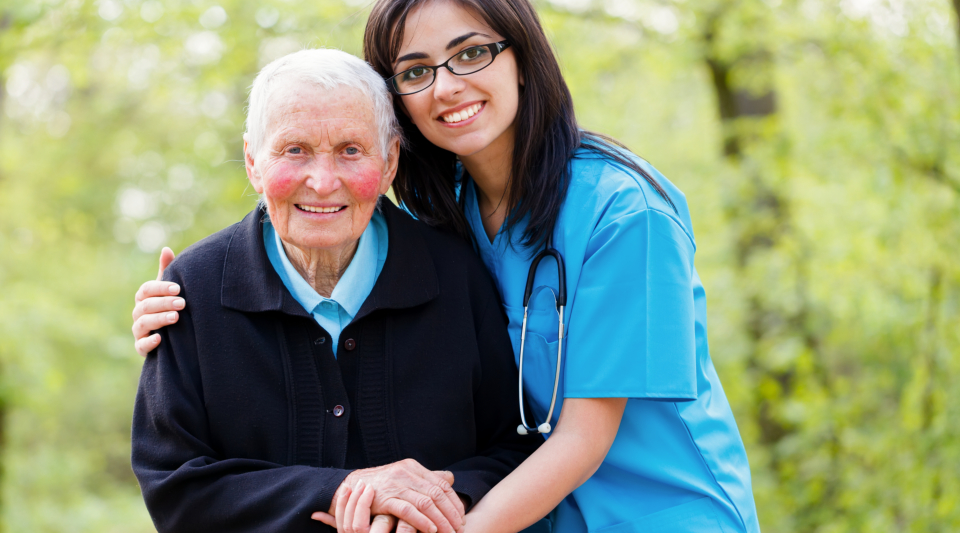 A nurse accompanying an ederly outside